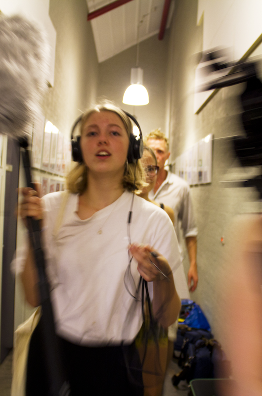 Ung pige holder mikrofon til optagelse af film.